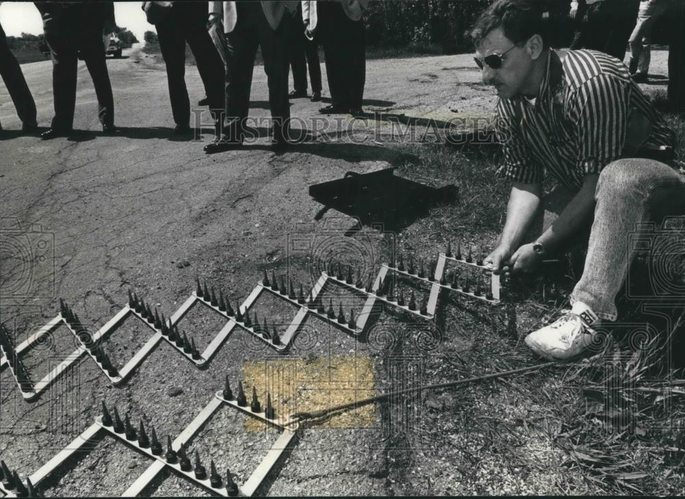 1992 Press Photo Oak Creek police officer, Thomas Peterson sets up road spikes - Historic Images