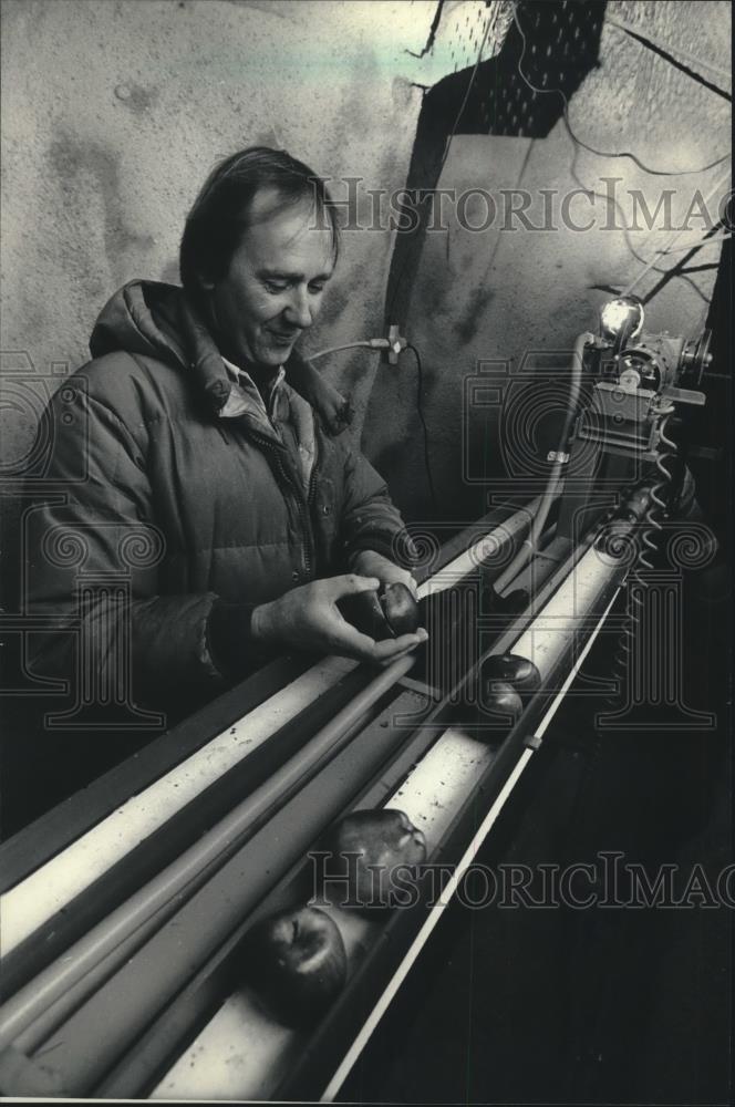 1987 Press Photo Milwaukee Zoo keeper loads apples on conveyer for polar bears - Historic Images