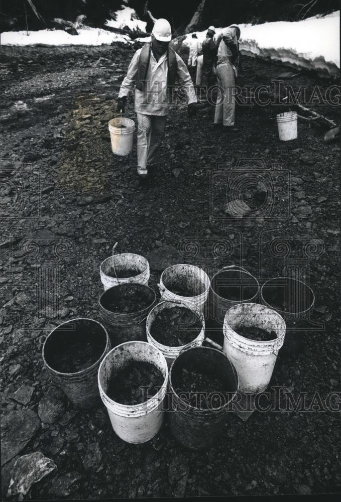 1990 Press Photo Exxon worker collects buckets of oiled sediment, Exxon Valdez - Historic Images