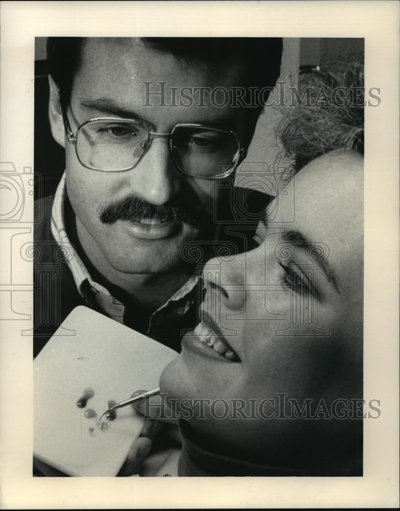 1986 Press Photo Dentist Barry Wolf applying Christmas design on patient&#39;s tooth - Historic Images