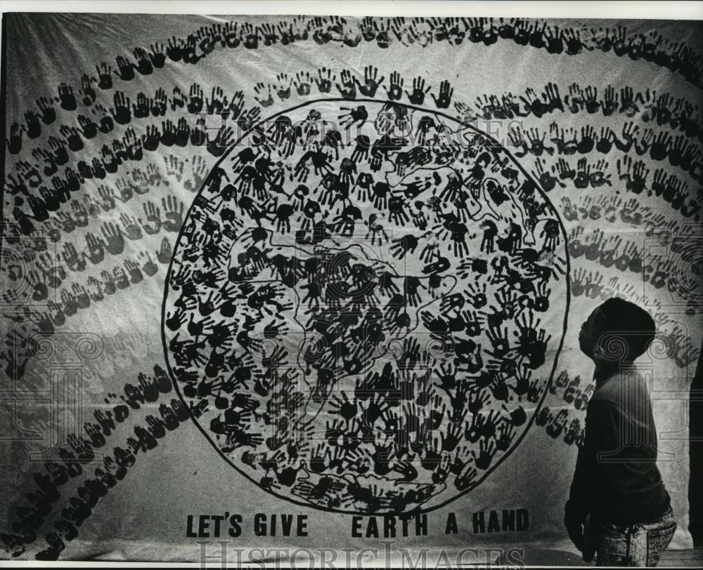 1990 Press Photo Lashun Gray examines a flag students made for Earth Day - Historic Images