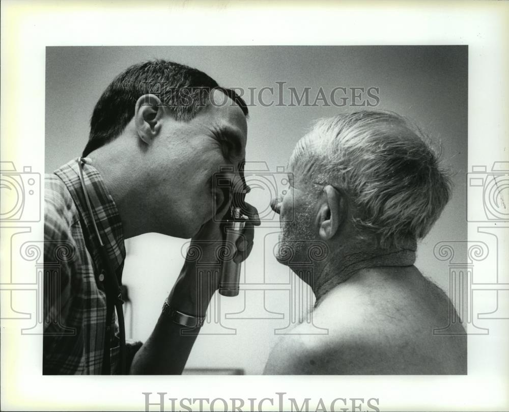 1987 Press Photo Doctor Timothy Devitt examines diabetic patient Burl Silbaugh - Historic Images