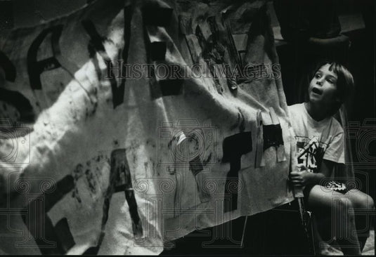 1990 Press Photo Zach Hudson holding "Save the Earth" sign, Wisconsin - Historic Images