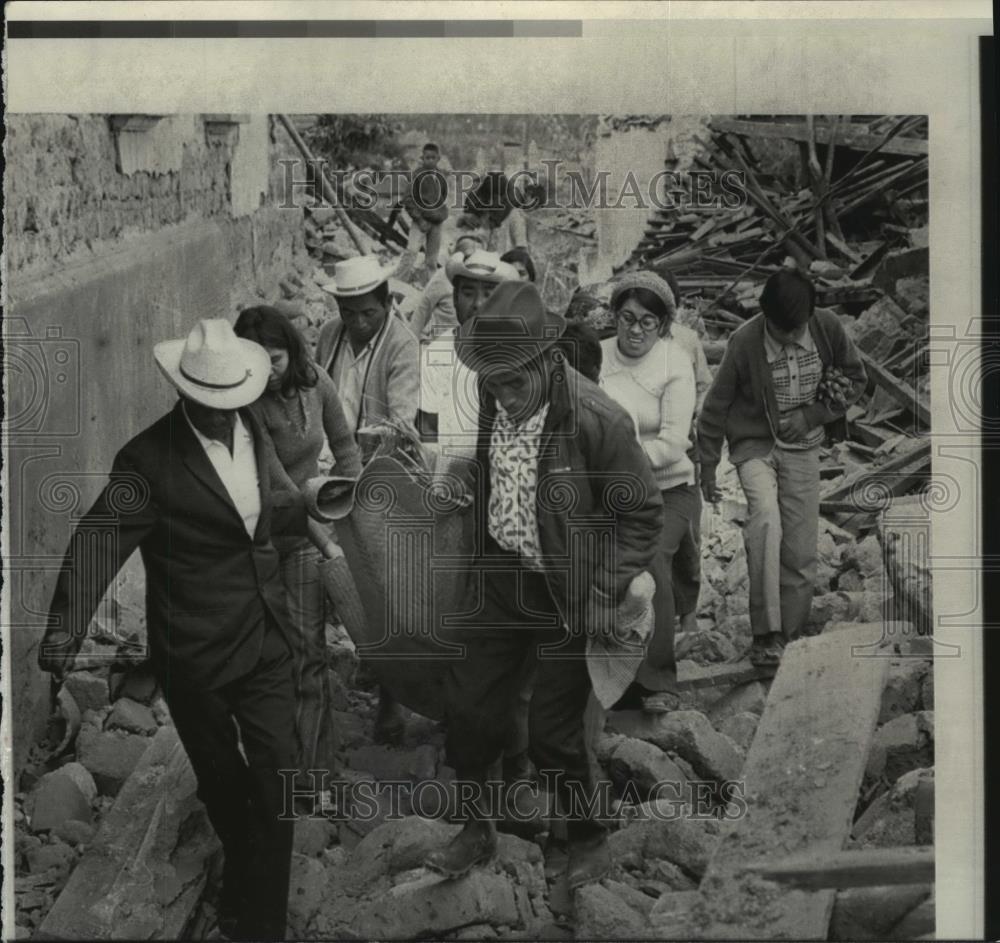 1976 Press Photo Residents carry an injured woman through rubble in Guatemala - Historic Images