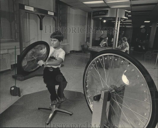 1984 Press Photo Justin Wobnick Plays with Wheel at Discovery World Exhibit - Historic Images