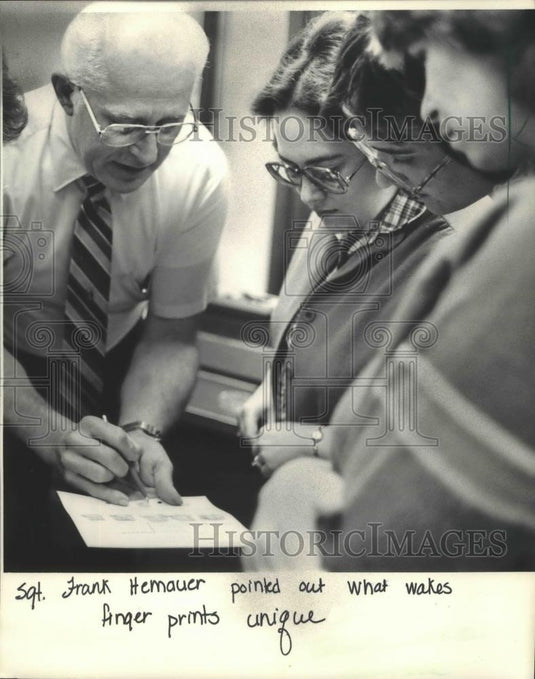 1983 Press Photo Police Sergeant Frank Hernauer explains fingerprints to parents - Historic Images