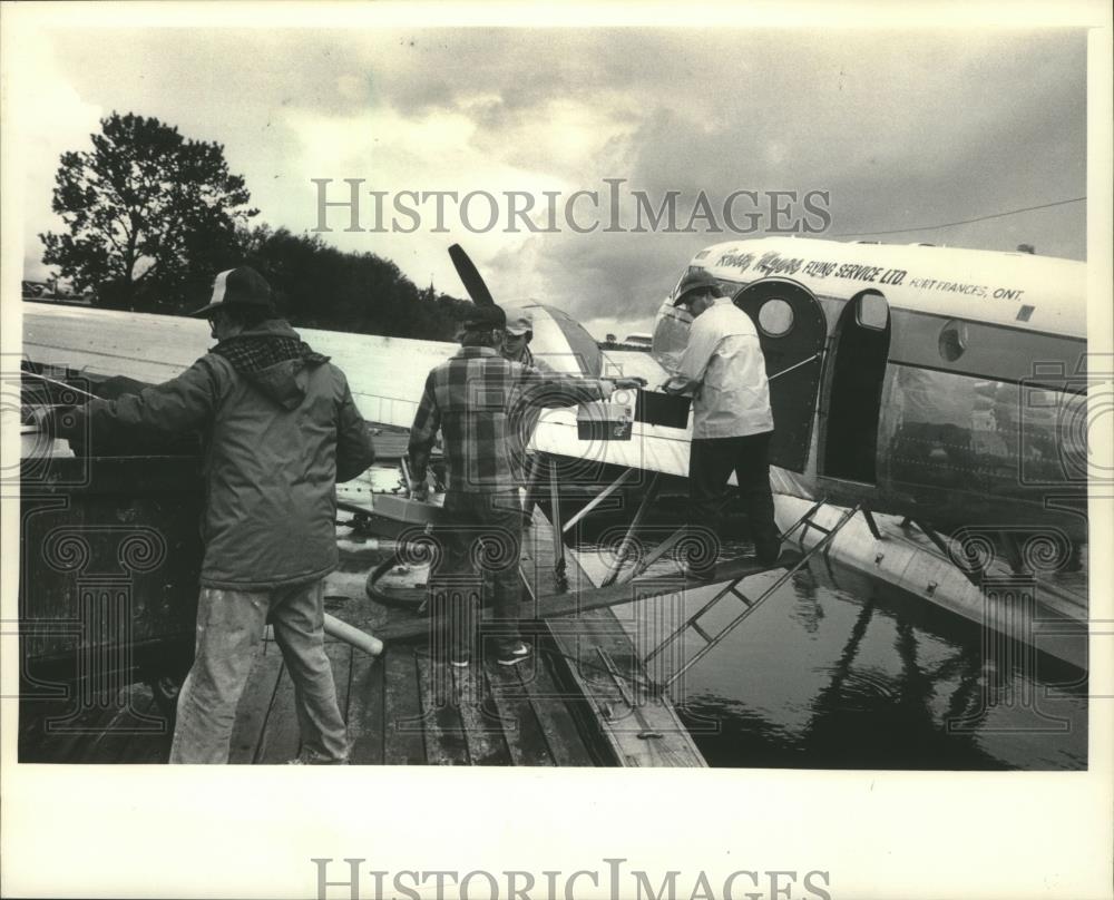 1985 Press Photo Joel McNally, Jim Gribble and Larry Boynton loading plane - Historic Images
