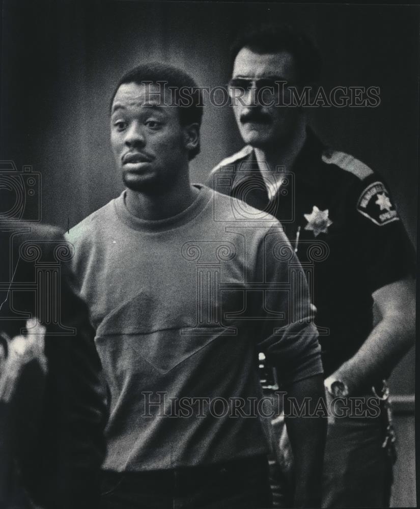 1985 Press Photo Phillip Harvey is escorted out of court for rape charge - Historic Images
