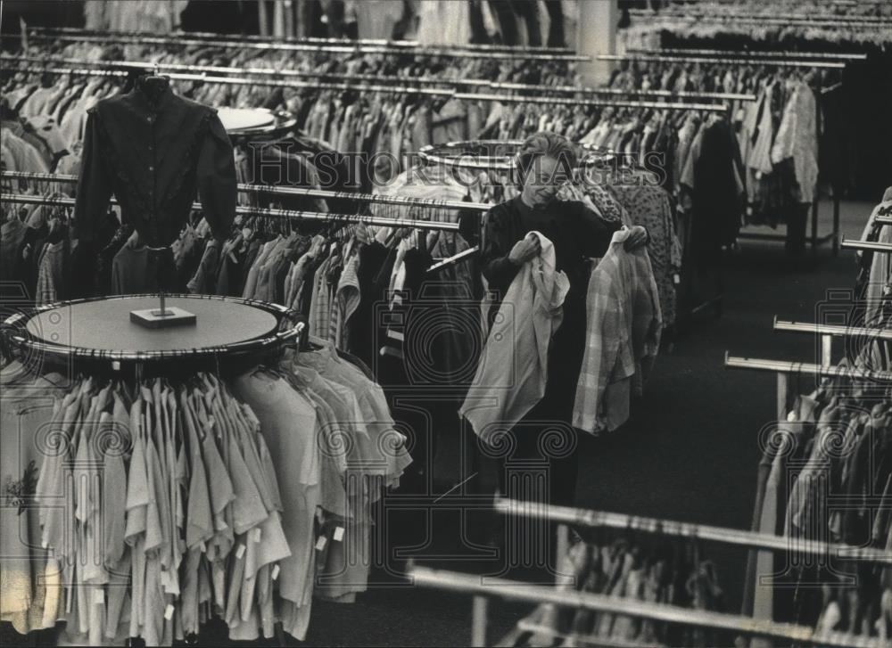 1991 Press Photo Eleanor Stevens, Fox Point, looks at clothes in Goodwill store - Historic Images