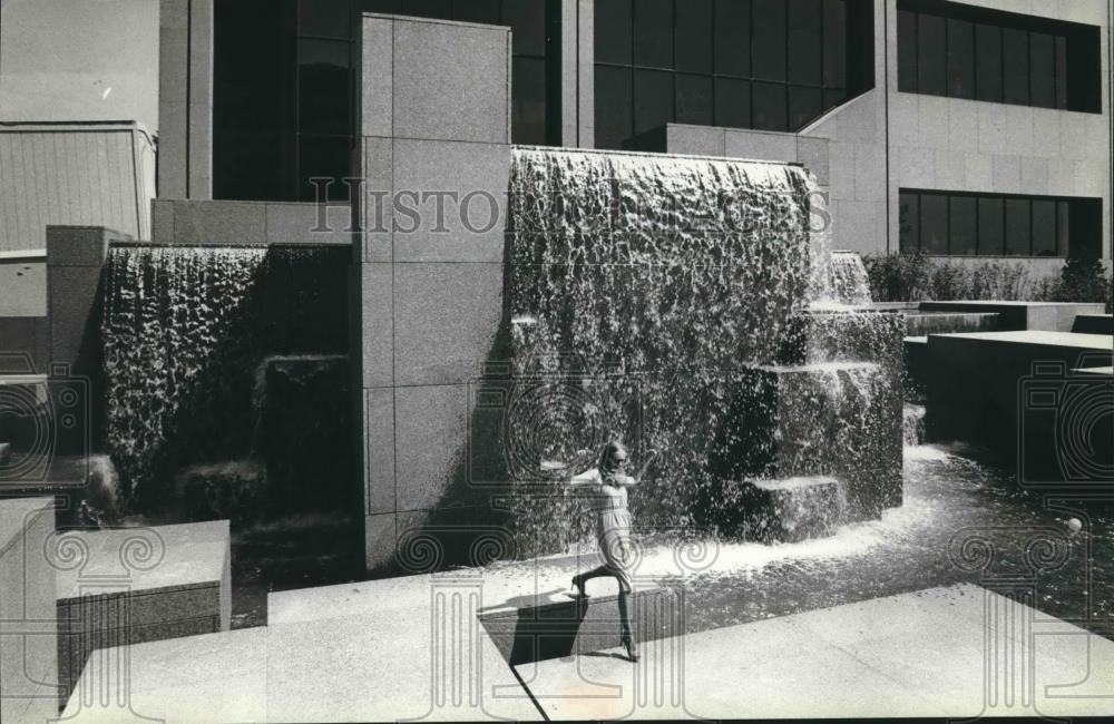 1980 Press Photo Girl frolics in futuristic fountain. Northwestern Mutual Life - Historic Images