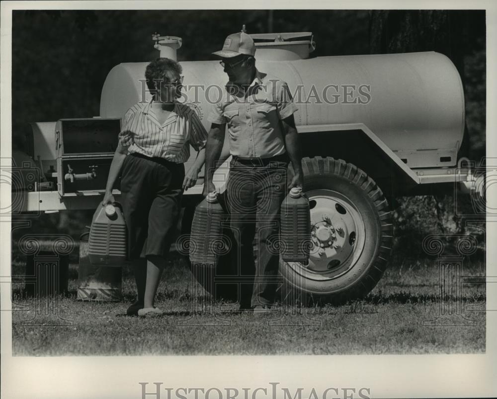 1986 Press Photo Alabama-Etowah County-Lady and man with green water containers. - Historic Images