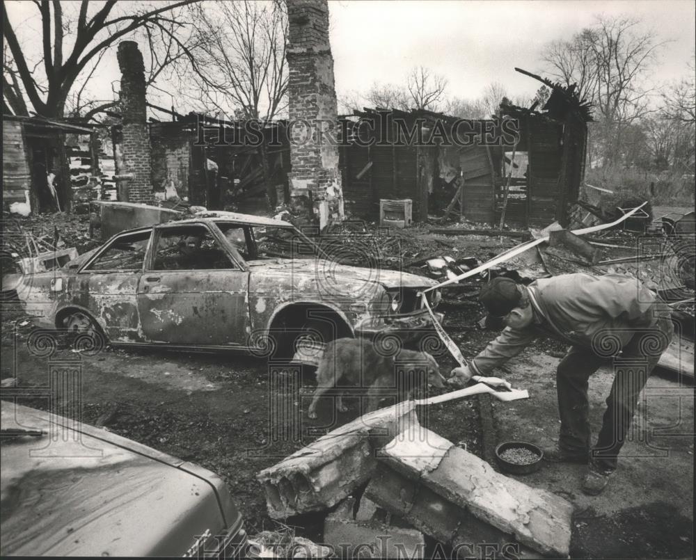 1987 Press Photo Captain Jimmy Denton Feeds Family Pet After Fire in Lipscomb - Historic Images