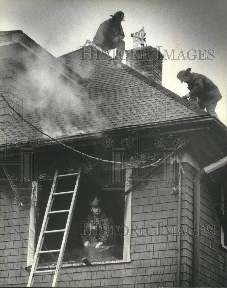 1980 Press Photo Fire fighters tackling fire on roof, inside building, Milwaukee - Historic Images