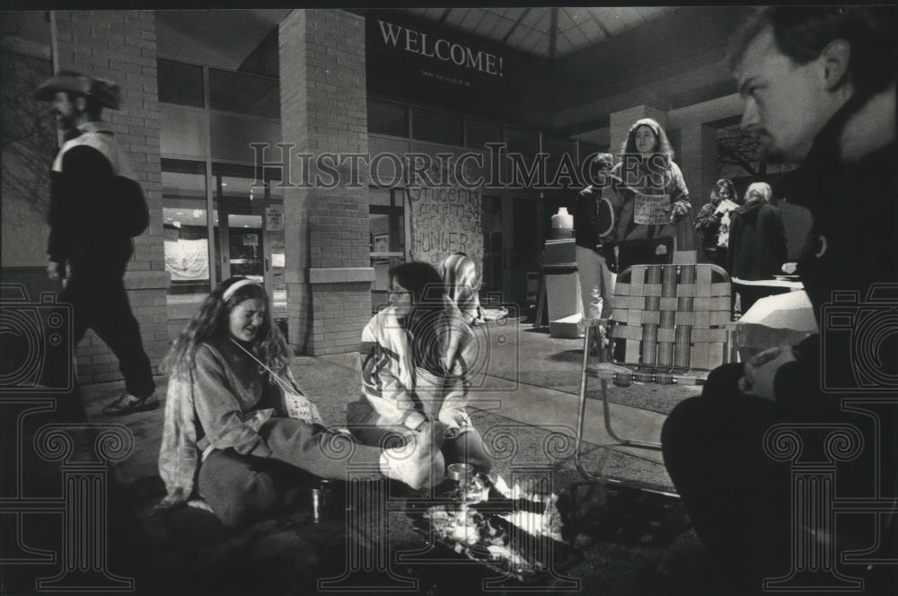 1992 Press Photo Nicolet High School student, Cindy Rosin, warms feet by fire - Historic Images