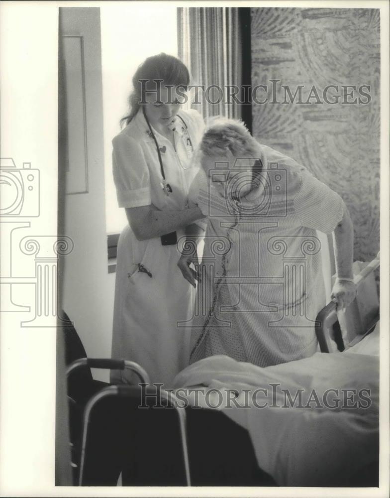 1984 Press Photo Nurse helps patient out of bed at Mount Sinai Medical Center - Historic Images