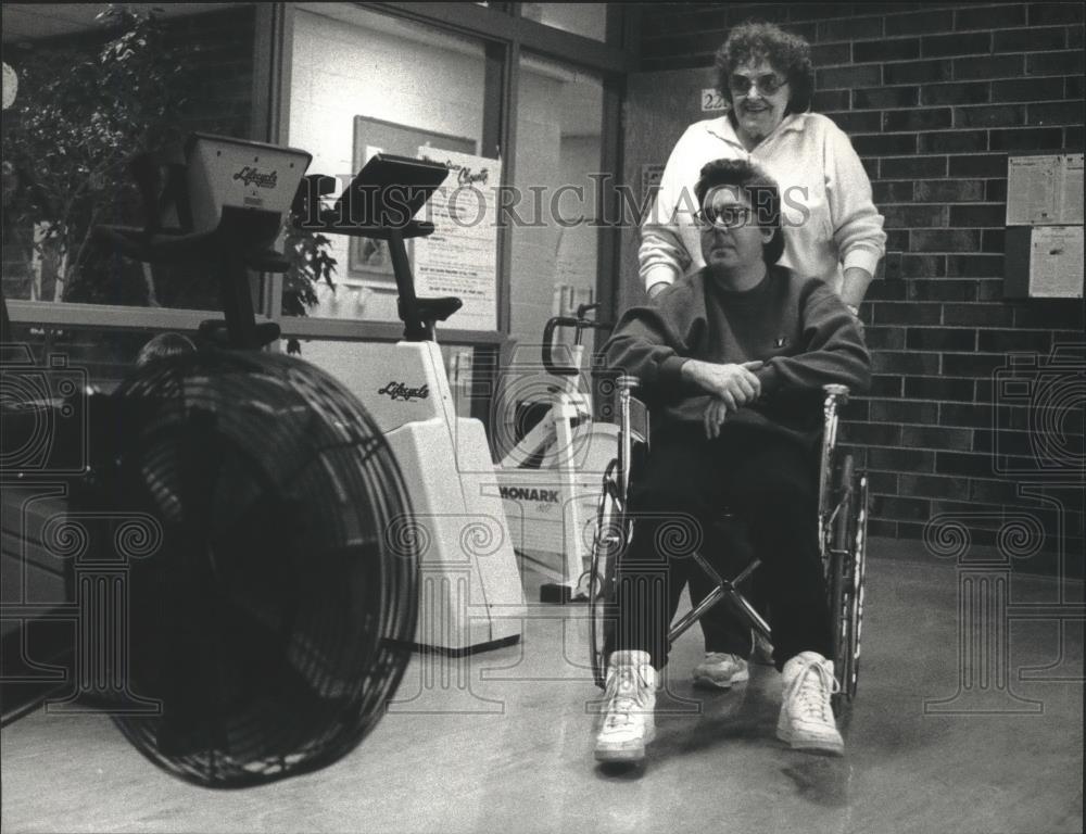 1993 Press Photo Joan Hinz pushes Bob Beaster into Waukesha, Wisconsin YWCA - Historic Images