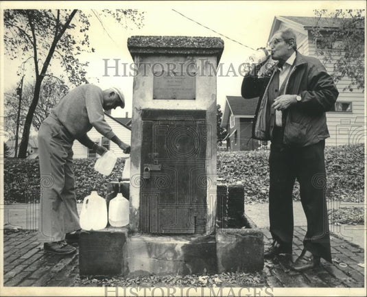 1985 Press Photo Frank Repensek and Marvin Zucker drink from well, Milwaukee - Historic Images