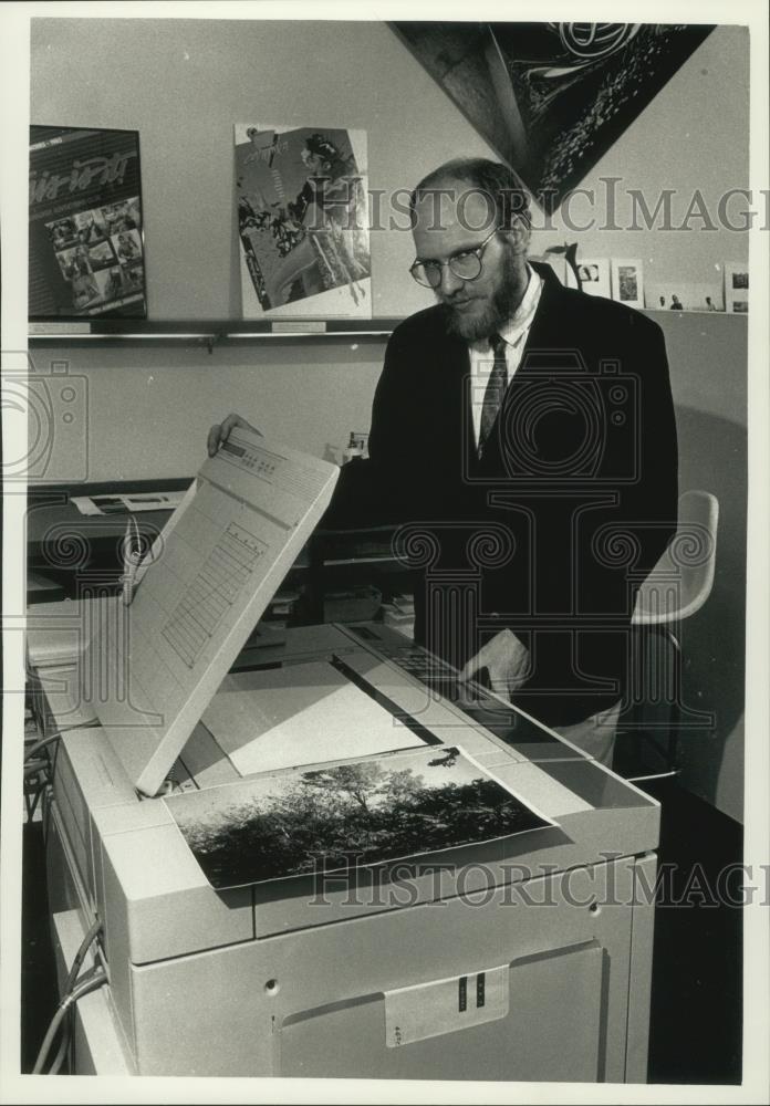 1989 Press Photo David Bolyard, manager, looks over Canon laser copier in store. - Historic Images