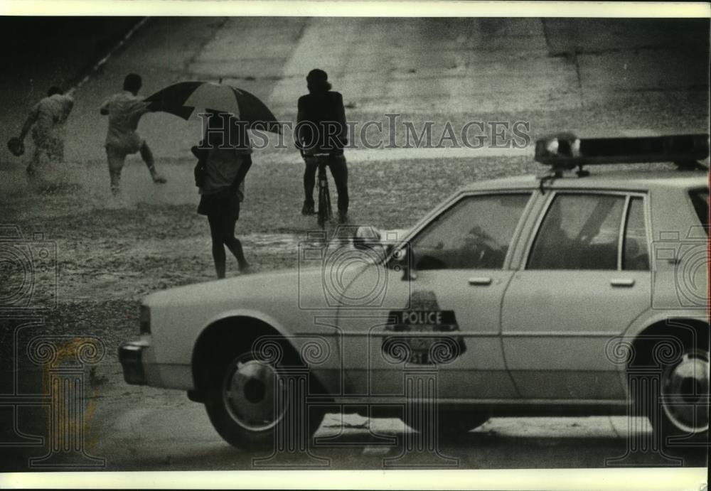 1989 Press Photo Milwaukee Police block flooded road as kids play in the water - Historic Images