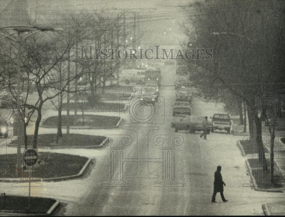 1988 Press Photo pedestrian carefully walks across snow-covered W. Locust St. - Historic Images
