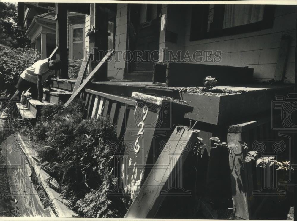 1991 Press Photo W.J. Knox plays on a dilapidated porch, W. Keefe Ave, Milwaukee - Historic Images