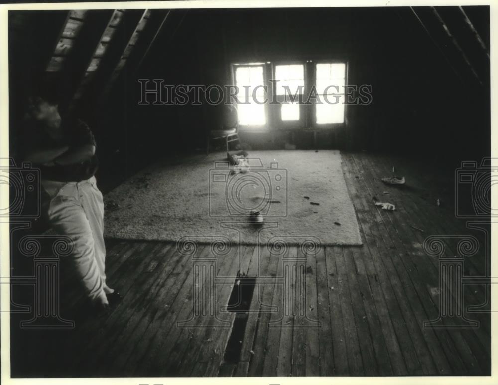 1994 Press Photo Milwaukee resident sits in attic of home in disrepair - Historic Images