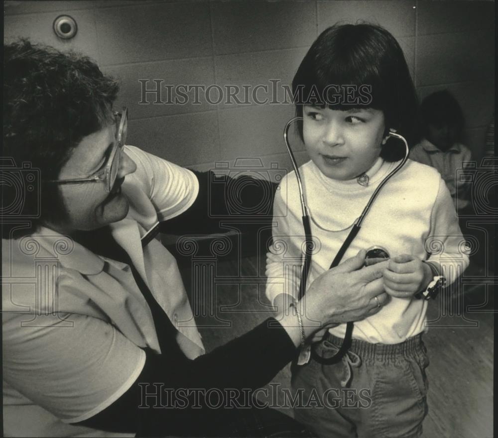 1987 Press Photo Dolores Emanuelson listens to Julie Ewalds heart at hospital. - Historic Images