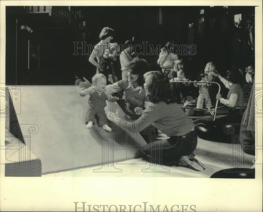 1983 Press Photo Mothers Cheered As Toddler Slides During Exercise Class - Historic Images