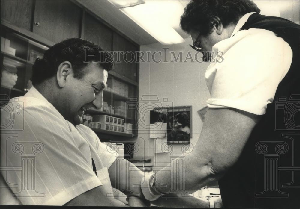 1989 Press Photo Josephine Smith, draws blood from Cudahy Mayor Peter Pekar. - Historic Images