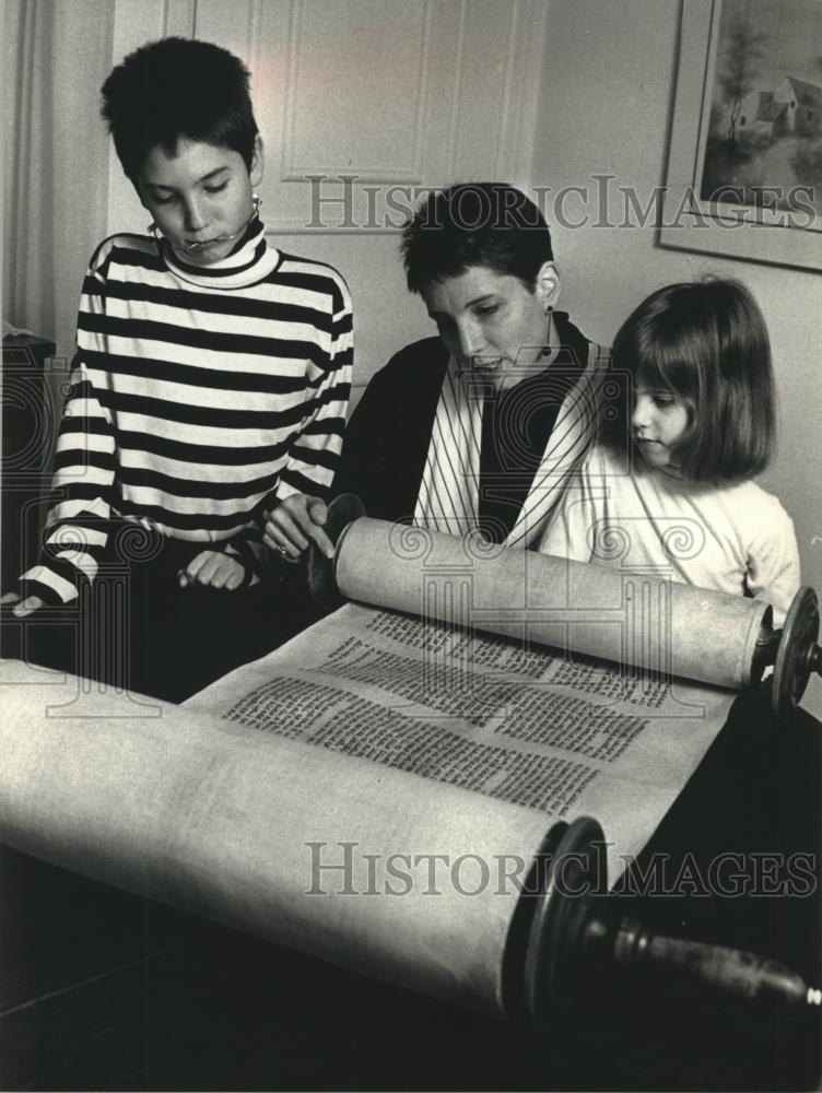 1990 Press Photo Marti Fine and children look over old Torah at Fox Point home - Historic Images