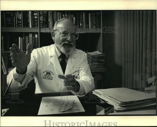 1988 Press Photo Charles Junkerman, an internist sitting at his desk. - Historic Images