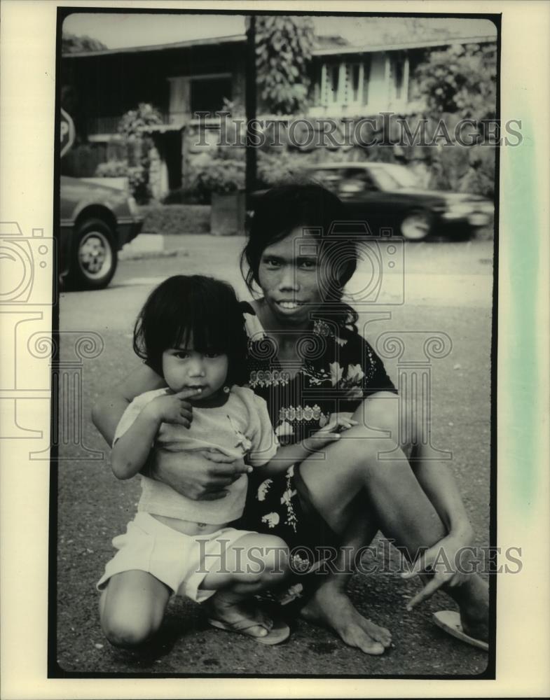 1986 Press Photo Woman and child beg for coins in Metro Manila, Philippines - Historic Images