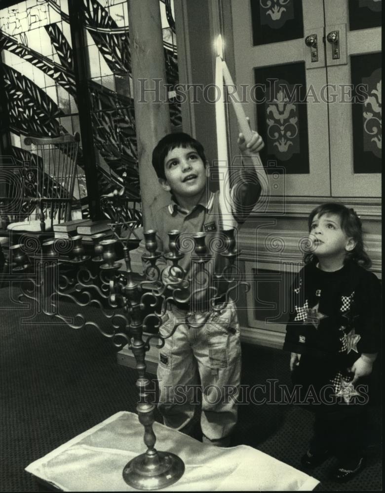 1992 Press Photo Miryam Lipper watches brother, Benjamin light candle in menorah - Historic Images