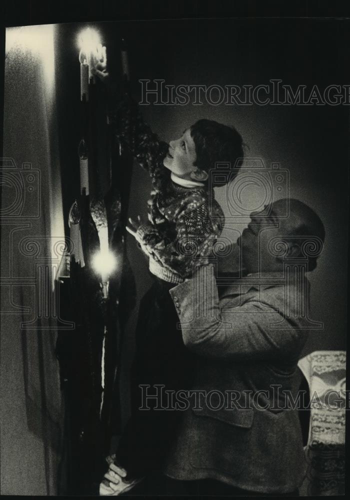 1991 Press Photo Jason Stern (L) lights menorah candle at Sinai Samaritan Center - Historic Images