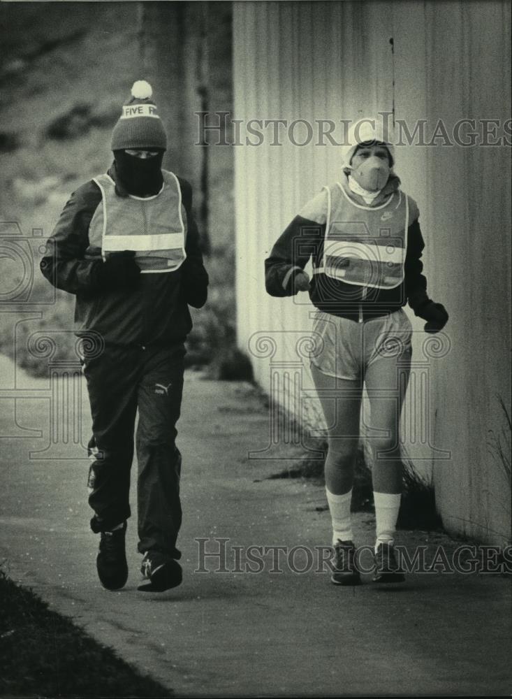 1986 Press Photo Bundled up, John and Rita Moran jog in cold weather, Milwaukee - Historic Images