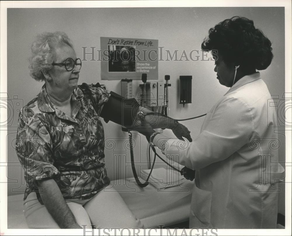 1986 Press Photo Dora K. Mullins gets blood pressure checked, Vertis Jimerson RN - Historic Images