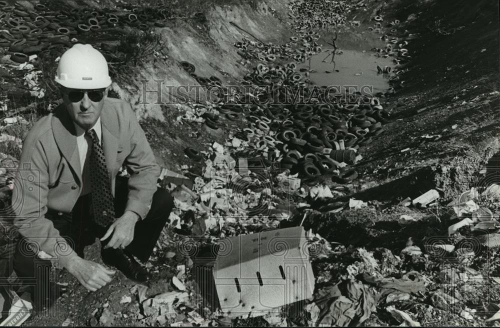 1981 Press Photo Griffin inspects hole where tires, debris are dumped, Alabama - Historic Images