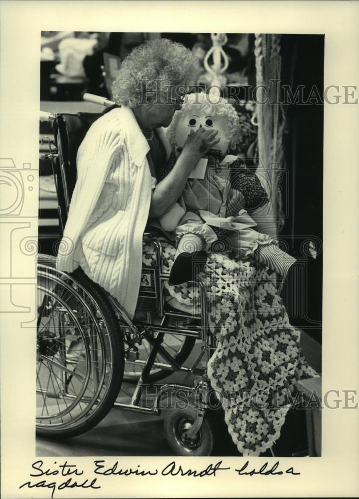 1985 Press Photo Sister Edwin Arndt inspects rag doll at St. Ann Health Center - Historic Images