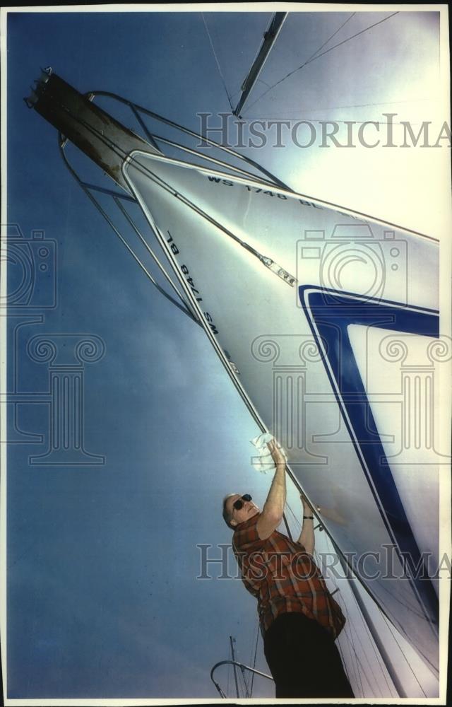 1993 Press Photo Charles Cook Sr., Waukesha wax the upper hull of his sailboat - Historic Images