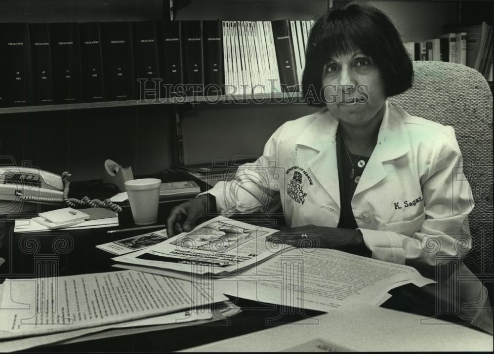 1990 Press Photo Kiran Sagar, sits at her desk, Cardiologist, Wisconsin - Historic Images