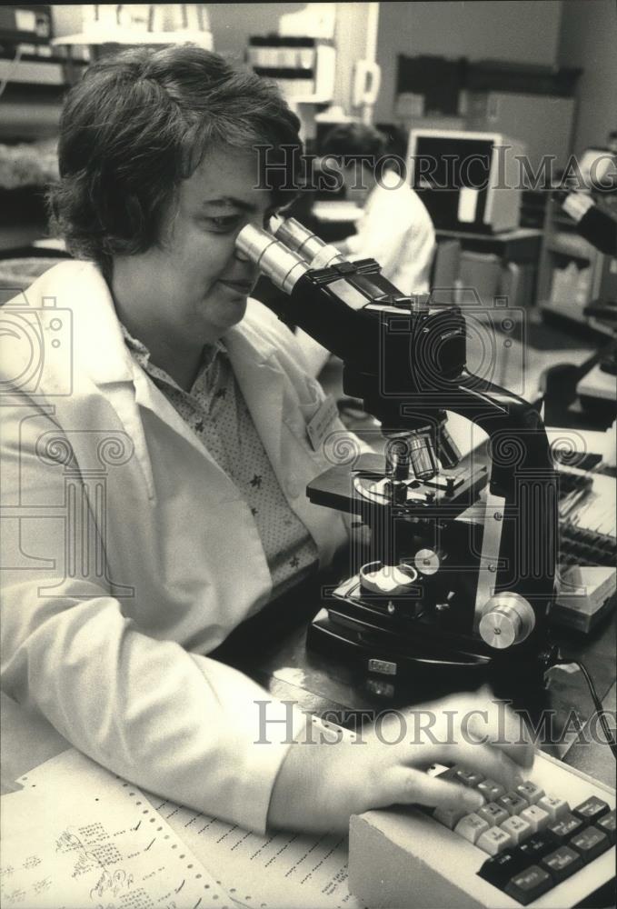 1988 Press Photo Ann Kaiserling examines slide. Saint Michael Hospital Milwaukee - Historic Images