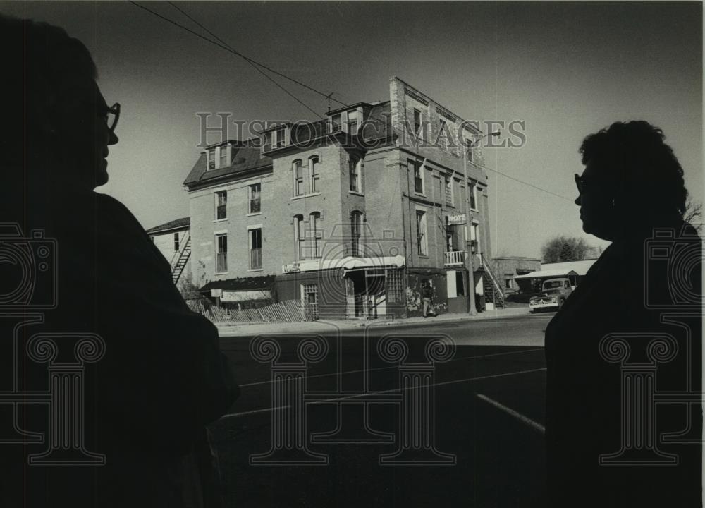 1979 Press Photo Two people silhouetted as they look at old building. - Historic Images