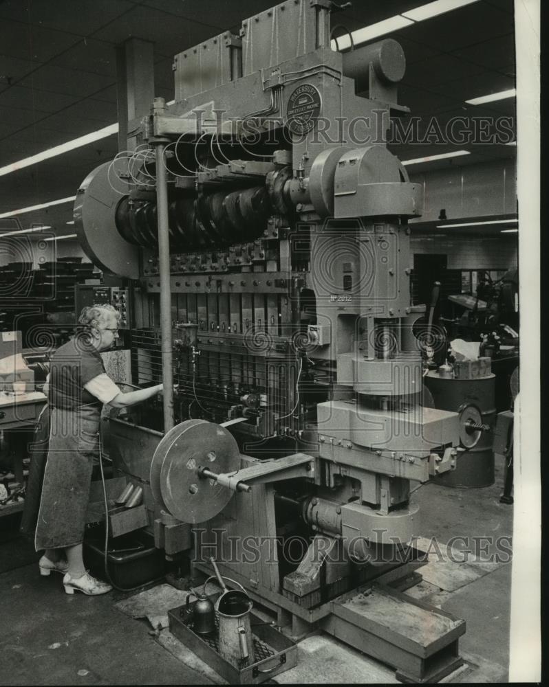 1983 Press Photo Woman uses big machine to farm metal caps at pen company - Historic Images