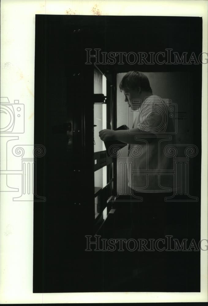 1993 Press Photo Shane Geisler collects money from soda machine, Port Washington - Historic Images