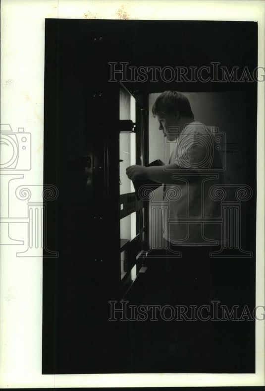 1993 Press Photo Shane Geisler collects money from soda machine, Port Washington - Historic Images