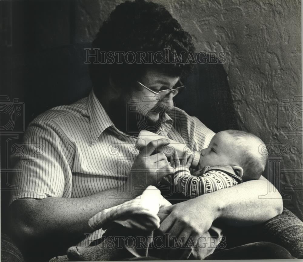 1980 Press Photo Warm bottle of milk brings Carl &amp; Christopher Schwartz together - Historic Images