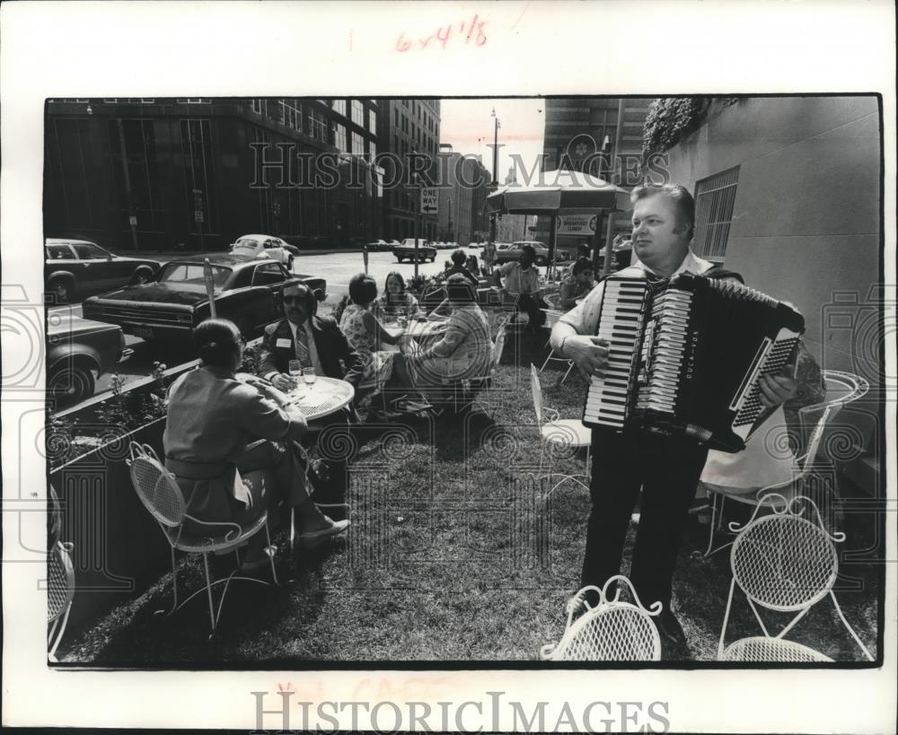 1977 Press Photo Musician plays for patrons at Smug&#39;s sidewalk cafe - mjb91279 - Historic Images