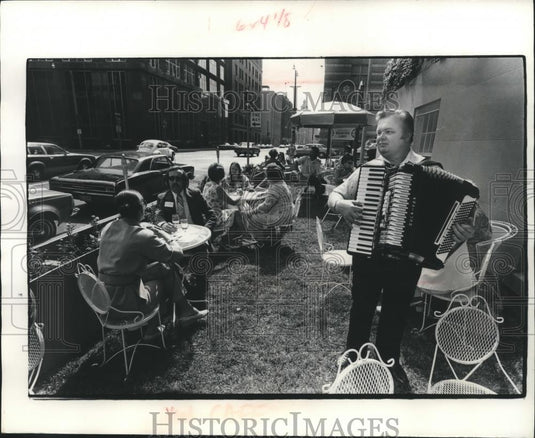 1977 Press Photo Musician plays for patrons at Smug's sidewalk cafe - mjb91279 - Historic Images