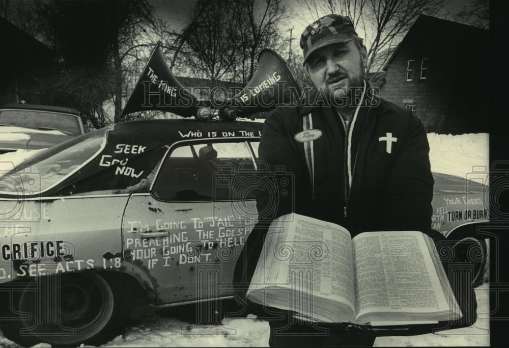 1985 Press Photo Ron Stania poses in front of his car, street preacher Milwaukee - Historic Images