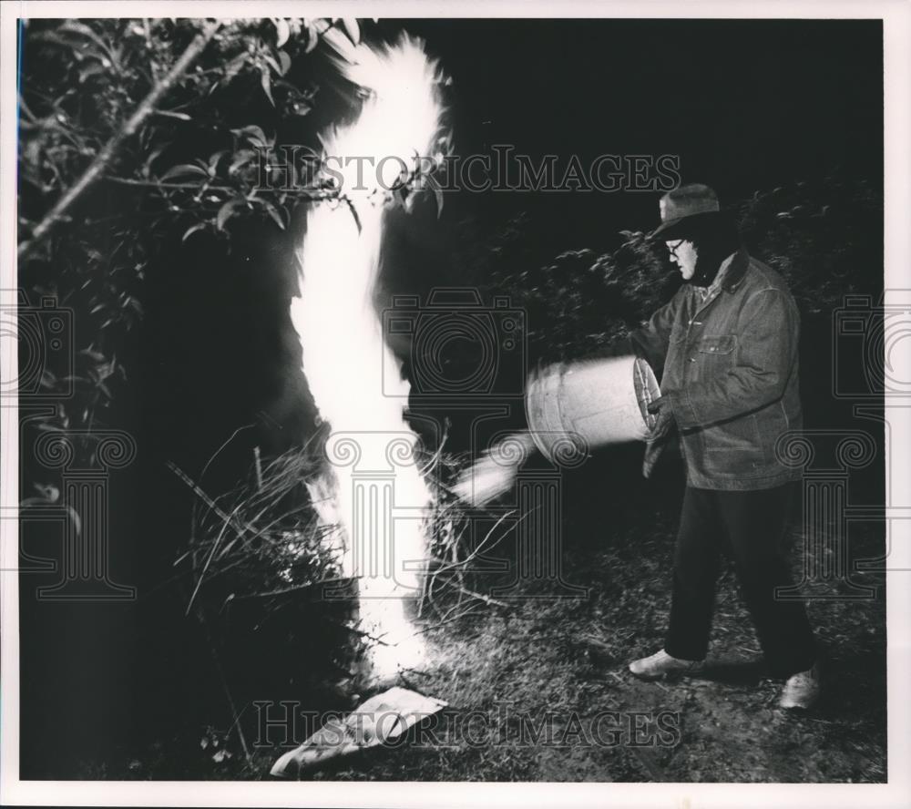 1987 Press Photo Peach grower Herschel Patterson pours fuel into smudge pot - Historic Images